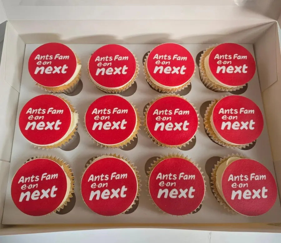 A box of branded cupcakes with edible logo toppers