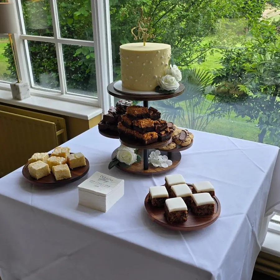 A lemon wedding cake surrounded by cake stands of traybakes at Makeney Hall
